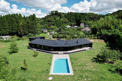 Aménagement d'une façade de maison métallique et noire moderne de plain-pied et de taille moyenne avec un toit à deux pans, un toit en métal et un toit noir.