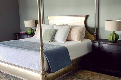 Modelo de dormitorio principal y blanco rústico con paredes verdes, suelo de madera oscura, suelo marrón y machihembrado