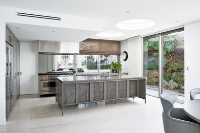 Design ideas for a large contemporary galley open plan kitchen in Sydney with a double-bowl sink, flat-panel cabinets, grey cabinets, concrete benchtops, grey splashback, mirror splashback, stainless steel appliances, concrete floors, with island, grey floor and grey benchtop.