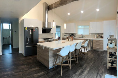 Enclosed kitchen - mid-sized modern l-shaped laminate floor and brown floor enclosed kitchen idea in San Francisco with an undermount sink, quartzite countertops, beige backsplash, glass tile backsplash, black appliances, an island, white countertops, flat-panel cabinets and white cabinets