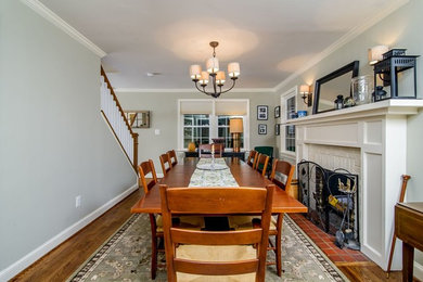Example of a mid-sized mid-century modern dark wood floor enclosed dining room design in Baltimore with gray walls, a standard fireplace and a brick fireplace