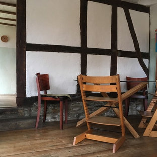 ドルトムントの広いコンテンポラリースタイルのLDKの画像 (白い壁、濃色無垢フローリング、標準型暖炉、石材の暖炉まわり、茶色い床)