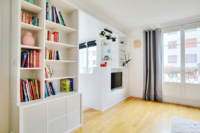 Idées déco pour une salle de séjour contemporaine de taille moyenne et ouverte avec une bibliothèque ou un coin lecture, un mur blanc, parquet clair, aucune cheminée et un sol beige.