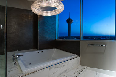 Mid-sized trendy master white tile and marble tile porcelain tile and white floor bathroom photo in Austin with flat-panel cabinets, medium tone wood cabinets, a bidet, gray walls, an undermount sink, quartz countertops and a hinged shower door