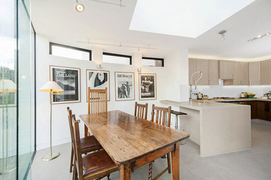 Inspiration for a mid-sized contemporary kitchen/dining combo in London with white walls and grey floor.
