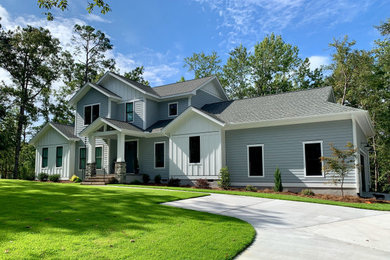 Ejemplo de fachada de casa gris y gris de estilo americano de tamaño medio de dos plantas con revestimiento de aglomerado de cemento, tejado a dos aguas, tejado de teja de madera y panel y listón