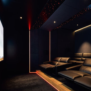 Idées déco pour une salle de cinéma contemporaine de taille moyenne et fermée avec un mur noir, moquette, un écran de projection et un sol noir.