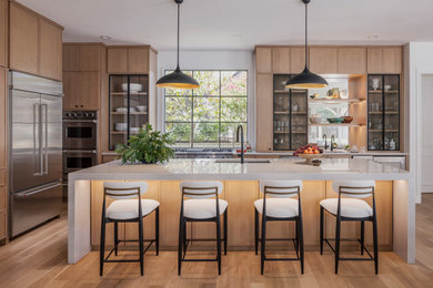 Large transitional l-shaped light wood floor and brown floor eat-in kitchen photo in Dallas with an undermount sink, light wood cabinets, quartzite countertops, white backsplash, stone slab backsplash, stainless steel appliances, an island and white countertops