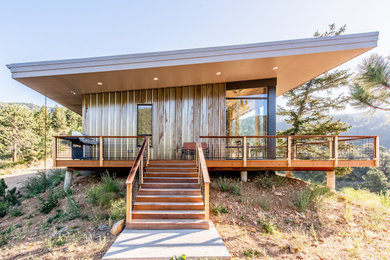 Example of a mid-sized 1960s brown one-story house exterior design in Denver with a shed roof and a white roof