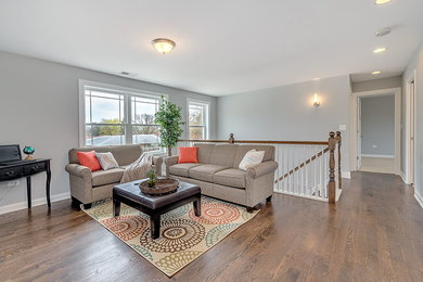Family room - large transitional open concept light wood floor family room idea in Chicago with gray walls
