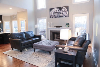 Inspiration for a mid-sized transitional formal and open concept medium tone wood floor and brown floor living room remodel in Atlanta with gray walls, a standard fireplace, a tile fireplace and no tv