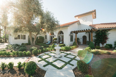 Design ideas for a mid-sized traditional full sun front yard concrete paver formal garden in Other.
