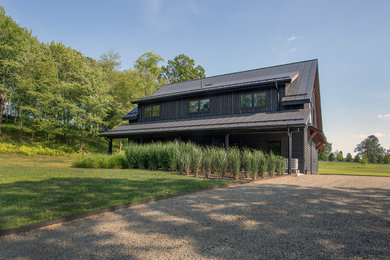 Example of a large transitional black two-story wood exterior home design in New York with a metal roof and a black roof