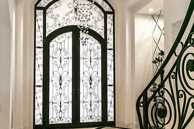 Large transitional marble floor and brown floor entryway photo in Los Angeles with white walls and a brown front door