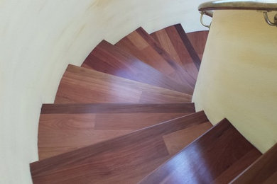 Large traditional wood spiral staircase in San Francisco with wood risers.