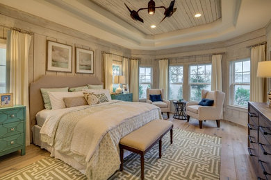 This is an example of a mid-sized beach style master bedroom in Miami with grey walls, light hardwood floors and no fireplace.