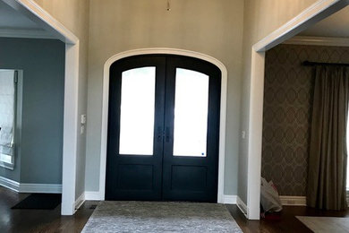 Photo of a mid-sized transitional foyer in New York with beige walls, dark hardwood floors, a double front door, a black front door and brown floor.