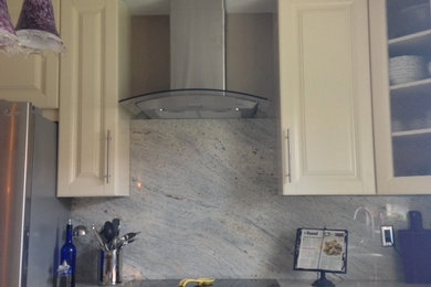Kitchen - mid-sized contemporary l-shaped kitchen idea in Other with an undermount sink, raised-panel cabinets, beige cabinets, granite countertops, blue backsplash, stainless steel appliances and an island