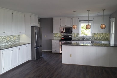 Eat-in kitchen - coastal dark wood floor eat-in kitchen idea in Other with recessed-panel cabinets, white cabinets, granite countertops, multicolored backsplash, mosaic tile backsplash, stainless steel appliances and an island