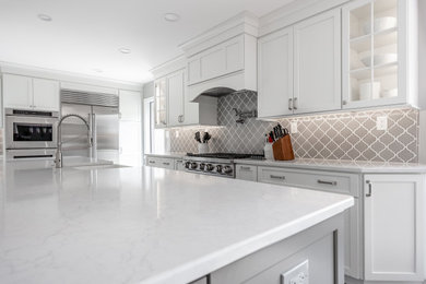 Inspiration for a large coastal galley vinyl floor eat-in kitchen remodel in Philadelphia with a farmhouse sink, recessed-panel cabinets, white cabinets, quartz countertops, gray backsplash, ceramic backsplash, stainless steel appliances, an island and white countertops