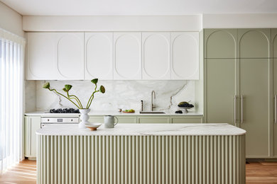 Foto på ett mellanstort funkis grå kök, med en undermonterad diskho, skåp i shakerstil, gröna skåp, marmorbänkskiva, grått stänkskydd, stänkskydd i marmor, rostfria vitvaror, ljust trägolv, en köksö och brunt golv