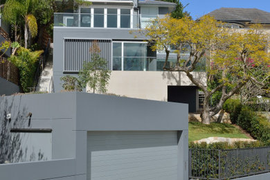 Inspiration for a contemporary three-storey stucco grey house exterior in Sydney with a hip roof and a shingle roof.