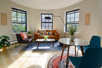 Ejemplo de salón abierto ecléctico pequeño con paredes beige, suelo vinílico, televisor colgado en la pared y suelo marrón