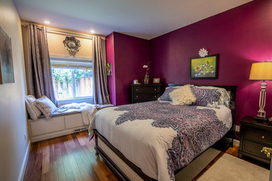 Example of a transitional medium tone wood floor bedroom design in Seattle with purple walls