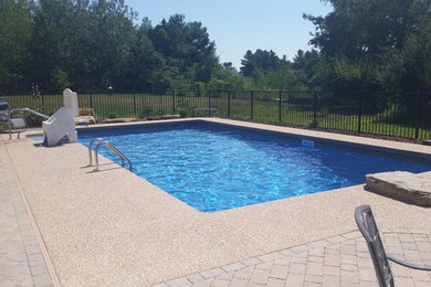 Example of a mid-sized classic backyard brick and rectangular lap hot tub design in Manchester