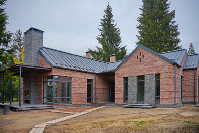 Пример оригинального дизайна: одноэтажный, кирпичный, красный частный загородный дом среднего размера в стиле рустика с двускатной крышей, металлической крышей и серой крышей