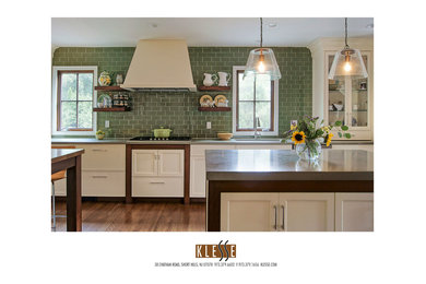 Medium tone wood floor kitchen photo in New York with green backsplash and gray countertops