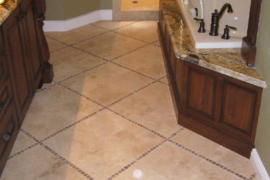 Inspiration for a large master beige tile and ceramic tile ceramic tile bathroom remodel in Orlando with raised-panel cabinets, dark wood cabinets, granite countertops, a hot tub and beige walls