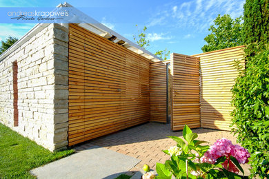 Kleiner Moderner Garten im Sommer mit direkter Sonneneinstrahlung und Natursteinplatten in München