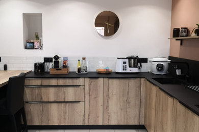 アンジェにあるお手頃価格の広いインダストリアルスタイルのおしゃれなキッチン (人工大理石カウンター、黒いキッチンパネル、セラミックタイルの床、白い床、黒いキッチンカウンター) の写真