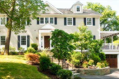Inspiration for a large timeless white two-story wood exterior home remodel in New York with a clipped gable roof