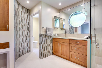 Photo of a large contemporary master bathroom in Sacramento with an undermount sink, recessed-panel cabinets, medium wood cabinets, engineered quartz benchtops, a corner shower, multi-coloured tile, glass tile and beige walls.