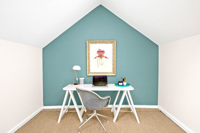 Photo of a small transitional home office with blue walls, carpet and a freestanding desk.