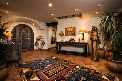 Entryway - southwestern terra-cotta tile entryway idea in Other with a dark wood front door