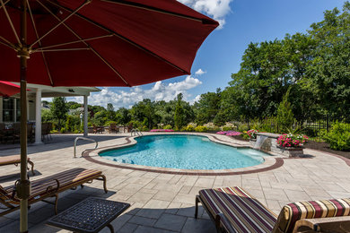 Pool fountain - mid-sized traditional backyard concrete paver and kidney-shaped infinity pool fountain idea in Providence