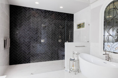 Réalisation d'une très grande salle de bain principale design avec un placard à porte shaker, des portes de placard blanches, une baignoire indépendante, une douche ouverte, un carrelage noir, des carreaux de porcelaine, un mur gris, un sol en carrelage de porcelaine, un plan de toilette en quartz modifié, un sol blanc, un plan de toilette blanc, un banc de douche, meuble double vasque et meuble-lavabo encastré.