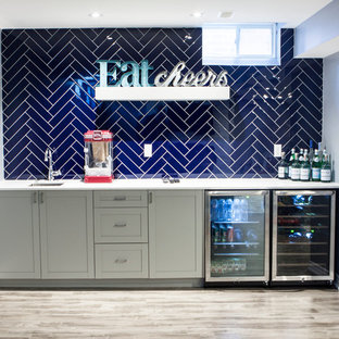 Inspiration for a medium sized modern look-out basement in Toronto with grey walls, laminate floors and grey floors.