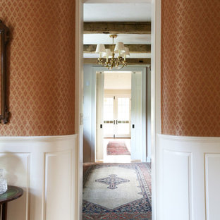 Exempel på en liten klassisk hall, med röda väggar och ljust trägolv