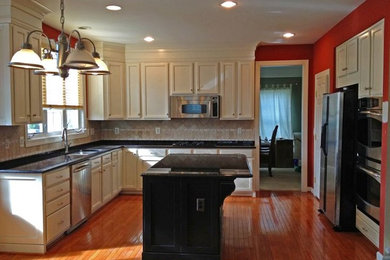 Inspiration for a mid-sized transitional l-shaped medium tone wood floor eat-in kitchen remodel in DC Metro with a drop-in sink, shaker cabinets, white cabinets, laminate countertops, beige backsplash, stone tile backsplash, stainless steel appliances and an island
