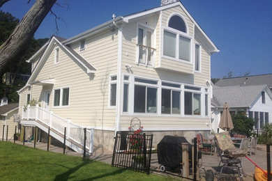 Mid-sized elegant beige two-story wood house exterior photo in New York with a shingle roof