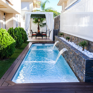 Idéer för en mellanstor modern träningspool längs med huset, med trädäck