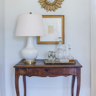 Idée de décoration pour un hall d'entrée bohème de taille moyenne avec un mur blanc, un sol en calcaire et un sol beige.