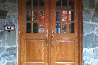 Example of a large arts and crafts entryway design in Denver with a medium wood front door
