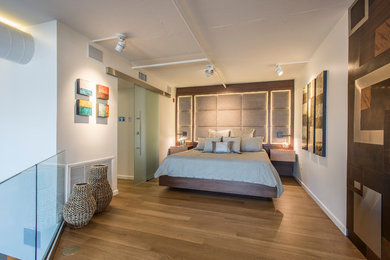 Inspiration for a contemporary loft-style light wood floor and beige floor bedroom remodel in Phoenix with white walls