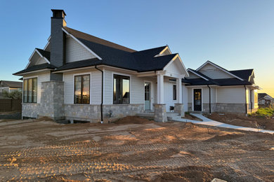 Example of a huge arts and crafts white two-story mixed siding and board and batten gable roof design in Salt Lake City with a shingle roof and a black roof