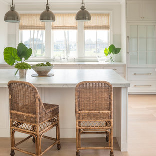 Large beach style kitchen pantry ideas - Kitchen pantry - large beach style u-shaped light wood floor kitchen pantry idea in Jacksonville with a double-bowl sink, beaded inset cabinets, white cabinets, marble countertops, green backsplash and an island